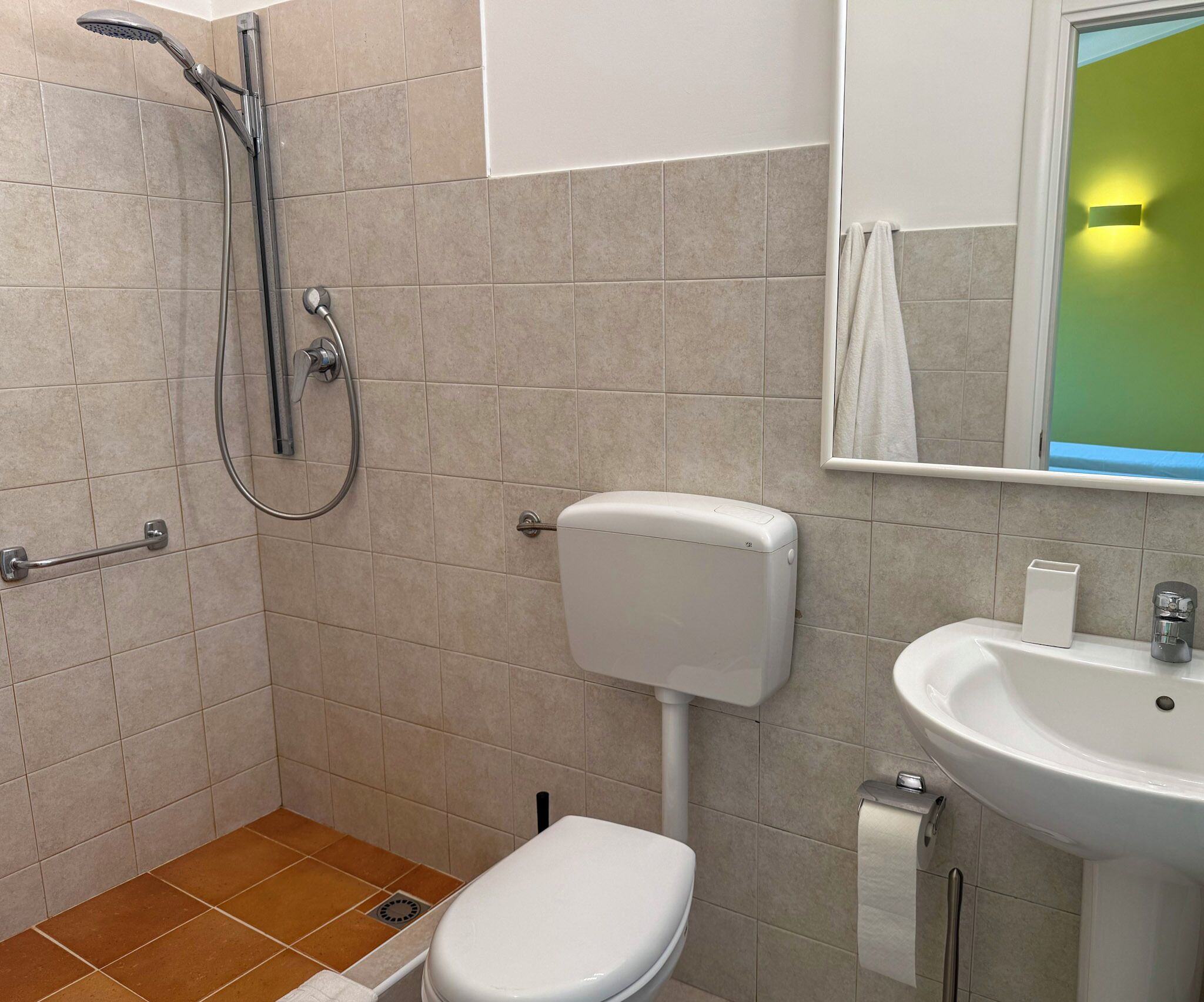 A small bathroom with a toilet, a sink, and a shower.