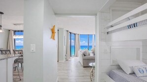 Ett modernt hotellrum med balkong, en matplats och utsikt över havet.