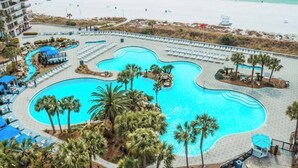 Ett semesterområde med en stor pool i mitten, flera mindre pooler och ett område med strand.