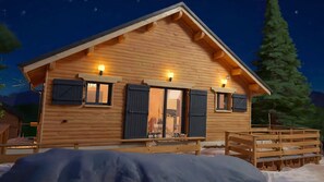 A wooden cabin with a pitched roof, large windows with shutters, and a porch area. - Le Chalet (Selonnet)