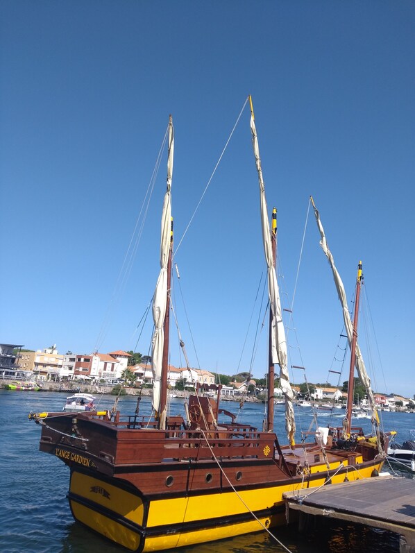 A traditional wooden boat docked at a marina with a clear blue sky in the background. - Duplex Apartment for a Beach Vacation (LE GRAU D'AGDE)