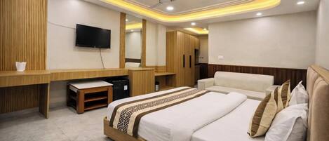 A hotel room with a bed, a desk, a television, and a ceiling fan.