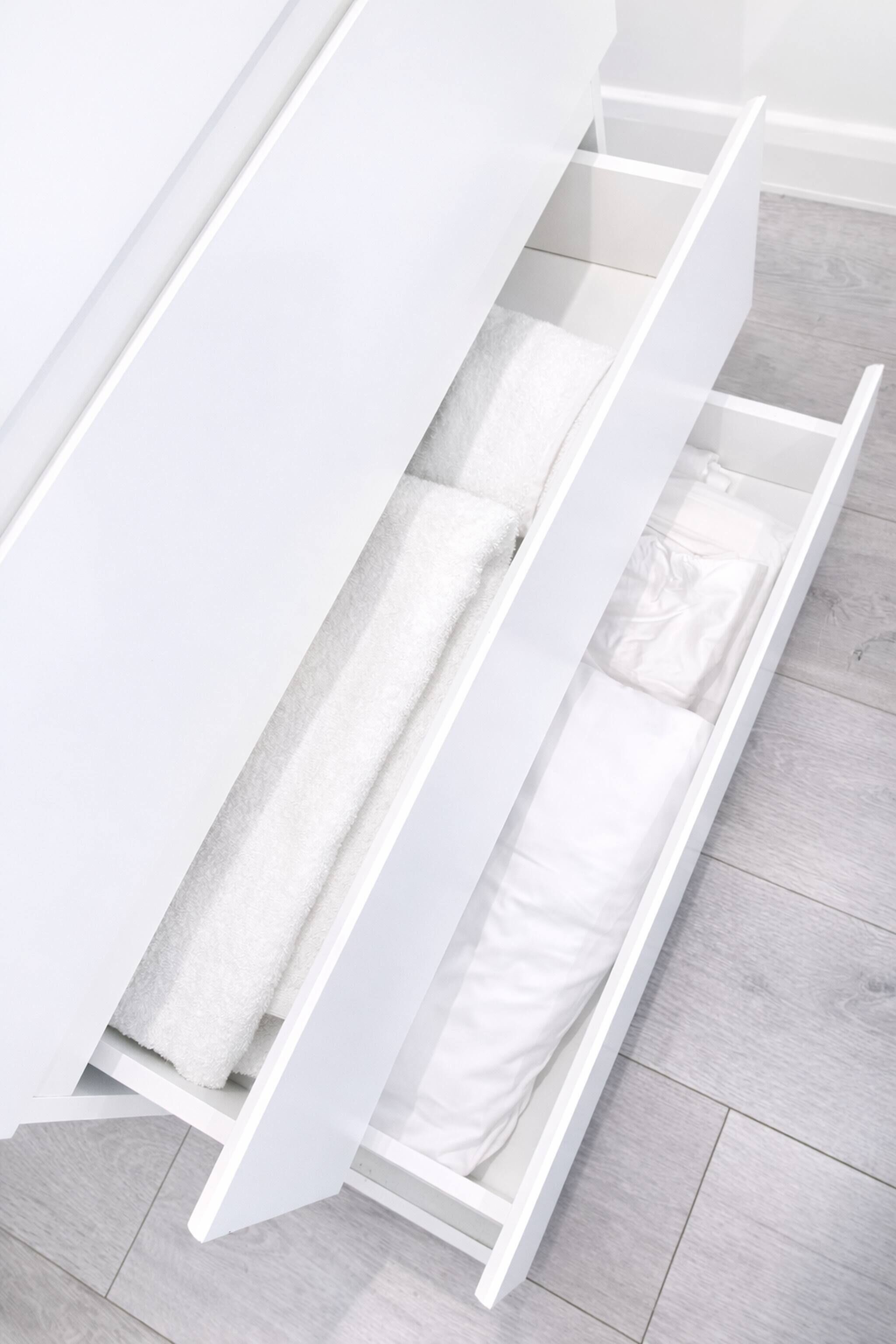 A white drawer unit with multiple compartments, likely for storage of linens or towels.