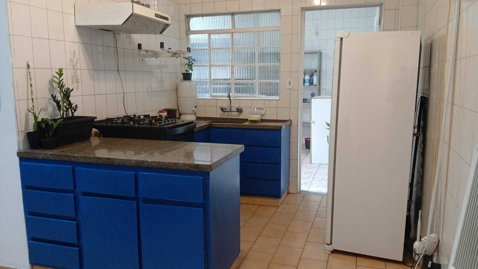 A kitchen with blue cabinets, a stove, and a window.