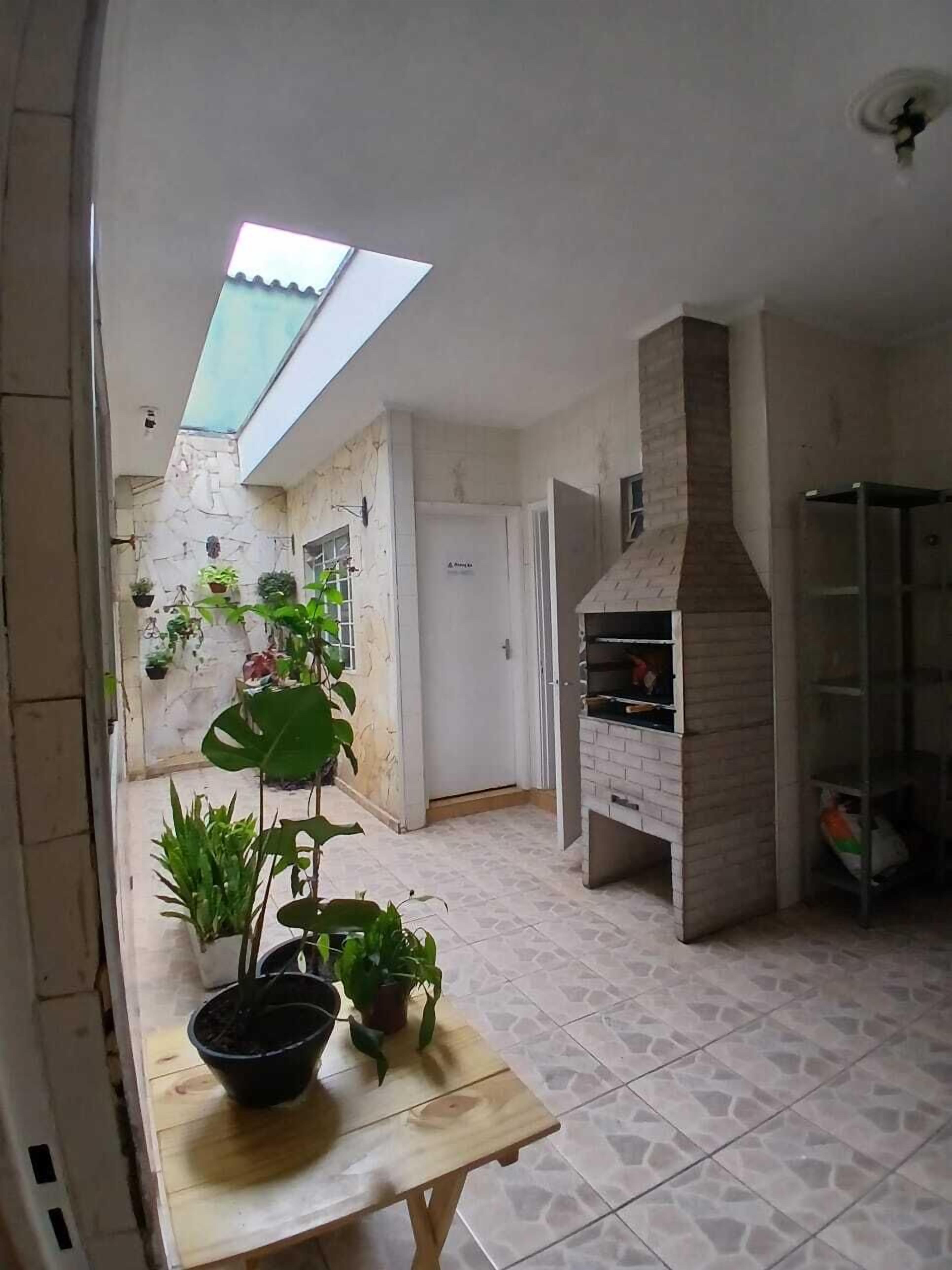 Un cortile con lucernario, forno a mattoni e piante in vaso.