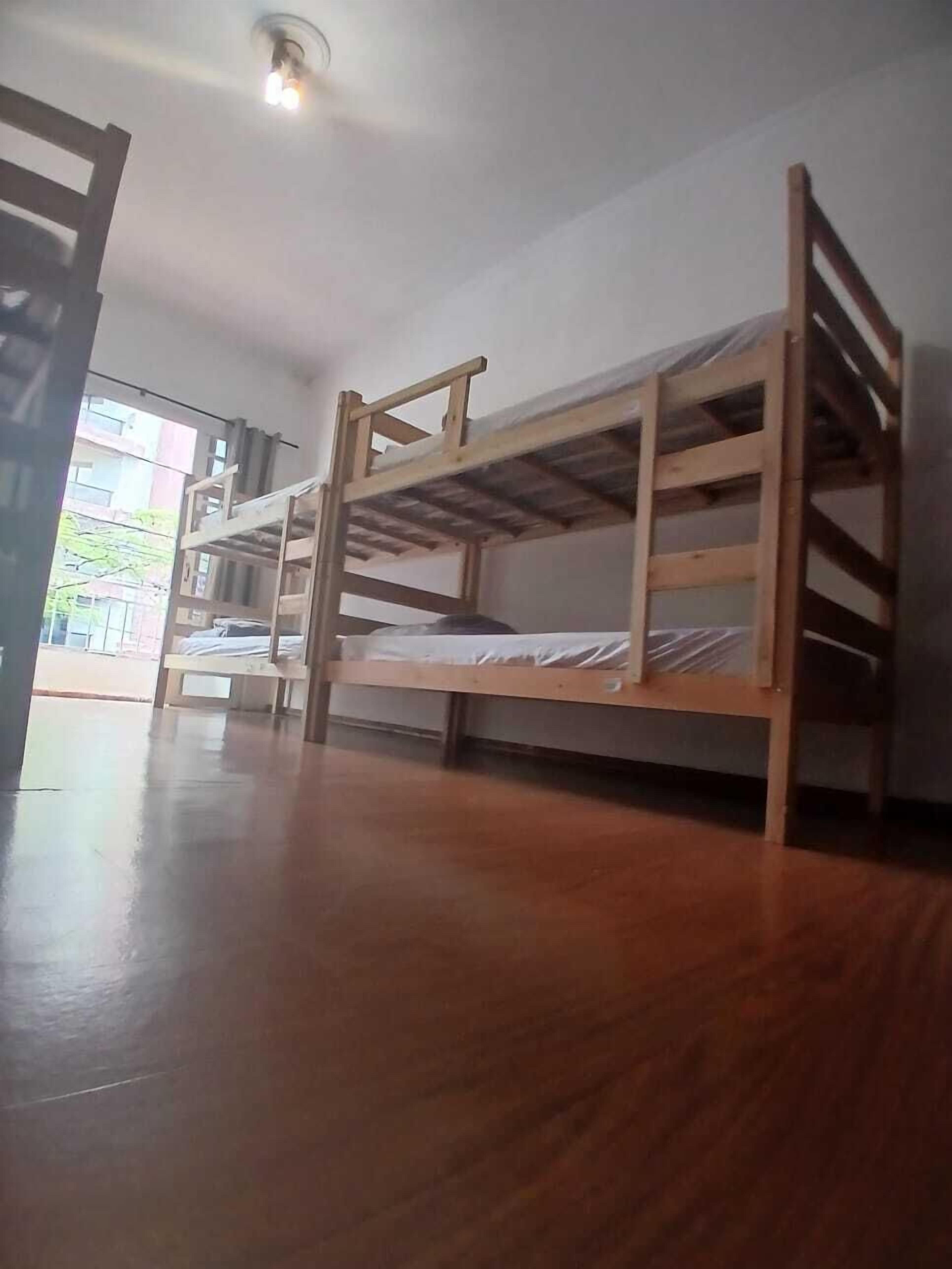 Habitació amb dos llits superposats, sòl de fusta i vista exterior.