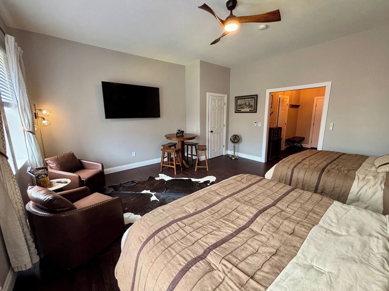 Ein Schlafzimmer mit einem großen Bett, einer Couch, einem kleinen Tisch und einem Deckenventilator.