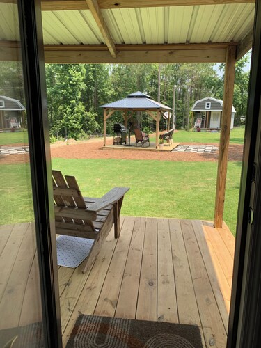 Modern tiny house with large outdoor area and grill.