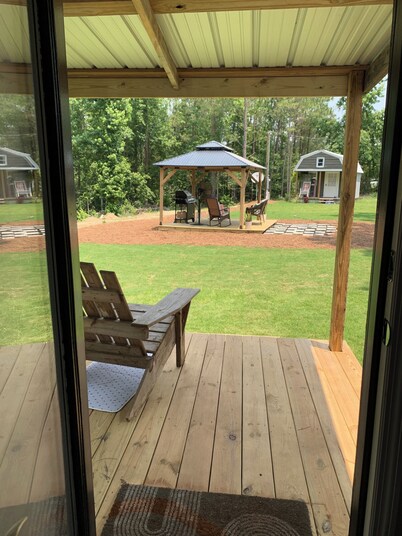 Modern tiny house with large outdoor area and grill.