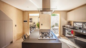 A modern kitchen with a central island, stainless steel appliances, and a view to an outdoor patio.