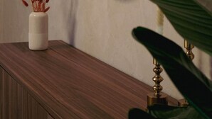 A bathroom with a wooden vanity, a round mirror, and a potted plant. - Atrium Apartments Aachen 1 (Aachen)