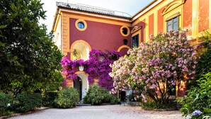 A building with a red facade, arched windows, and a gravel courtyard. - Don Paolo 2/4 people in a historic villa near Naples, Vesuvius, Pompeii, Caserta (Nola)