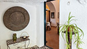 A hallway with a tiled floor, a decorative metal plate, a green vase, and a potted plant. - Don Paolo 2/4 people in a historic villa near Naples, Vesuvius, Pompeii, Caserta (Nola)