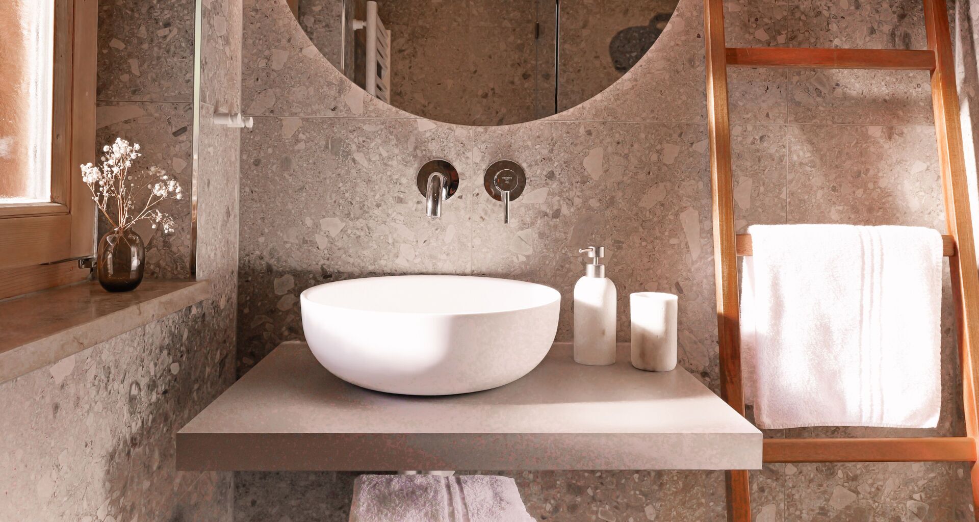 Une salle de bain avec un grand lavabo rond, un miroir et un porte-serviettes.