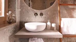 A bathroom with a large, round sink, a mirror, and a towel rack. - The newly renovated apartment (30 m²) has a combined living and sleeping area (Reit im Winkl)