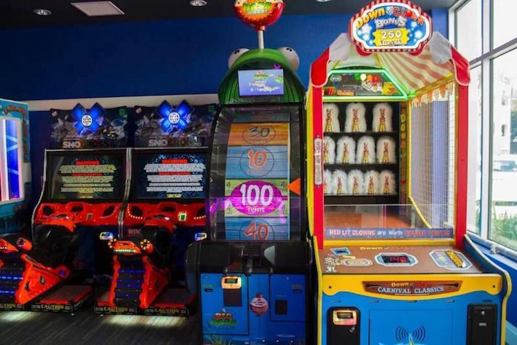 Una hilera de máquinas de videojuegos con distintos juegos y niveles de premios.