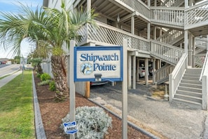 A sign for Shipwatch Pointe with a staircase leading to a parking area. - Shipwatch Pointe F317- 2 Bedroom- Walk to Beach (Myrtle Beach)
