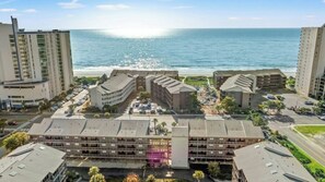 Ein Hotelkomplex an der Küste mit mehreren Gebäuden, Parkplätzen und Blick auf das Meer.