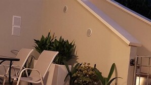 A swimming pool with lounge chairs and potted plants, a building with a sloped roof, and a visible moon in the sky. - "Calla Bianca "Borgo al Sole smart working, private pool nature and relaxation (Colombiera-Molicciara)