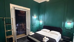 Un dormitorio con una cama grande, un candelabro y una puerta al balcón.