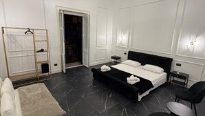 Un dormitorio moderno con una cama grande, una mesita de noche, una silla, un armario y una lámpara colgante.