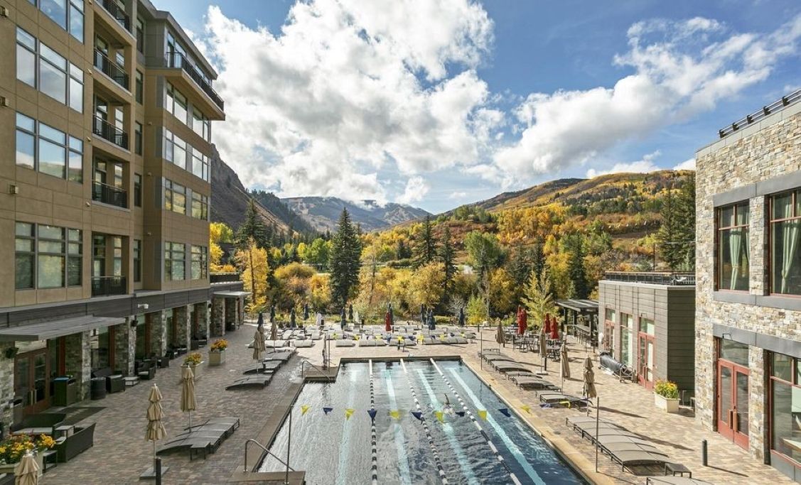 Un hôtel doté d’une piscine, d’un espace extérieur aménagé et offrant une vue sur les montagnes.