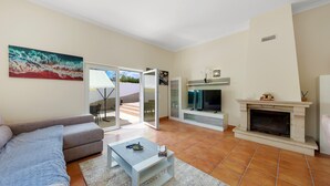 A living room with a sofa, a coffee table, a fireplace, and a television. - Casa Sun Zen – 4-Bedroom Villa with Pool and Snooker Table (Mexilhoeira Grande)