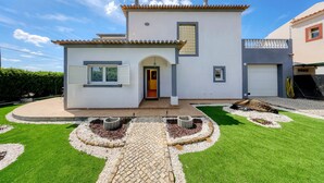 A modern two-story house with a tiled roof, a front entrance, and a driveway leading to a garage. - Casa Sun Zen – 4-Bedroom Villa with Pool and Snooker Table (Mexilhoeira Grande)