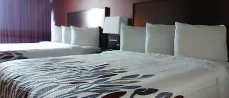 A hotel room with a large bed, two bedside tables, and a nightstand.