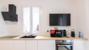 A modern kitchen with a built-in oven, a coffee maker, and a toaster. - GINO SUITES - Bilocali Luxury - Appartamenti vicini a Rho Fiera e Milano (Bollate)