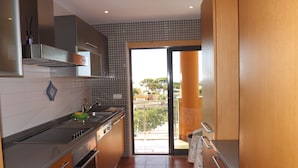 A modern kitchen with a large window, a built-in oven, and a sink. - Apartment 'Charming Ocean View' with Sea View, Wi-Fi and Air Conditioning (Albufeira)