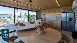 A modern kitchen with a large island, stainless steel appliances, and a city view. - Wake up in Barra with wide open beach views (Salvador)
