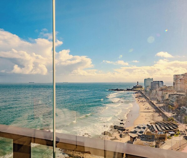 A coastal cityscape with a beach, ocean, and a lighthouse. - Brand new studio in a prime location in Barra (Salvador)