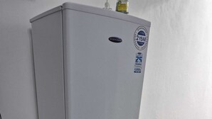 Un refrigerador blanco con compartimento congelador, un cable de alimentación y un enchufe.