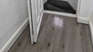 Una escalera estrecha con un pequeño ventanal en la parte superior, que da a una plataforma.