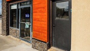 A building with a stone facade, a wooden panel on the left, and a black door on the right. - The Modern Loft at the foot of the Bighorns (Buffalo)