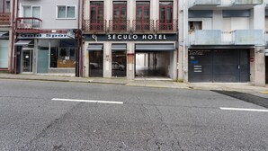 Un hotel con ingresso in vista, vetrina e area di parcheggio.