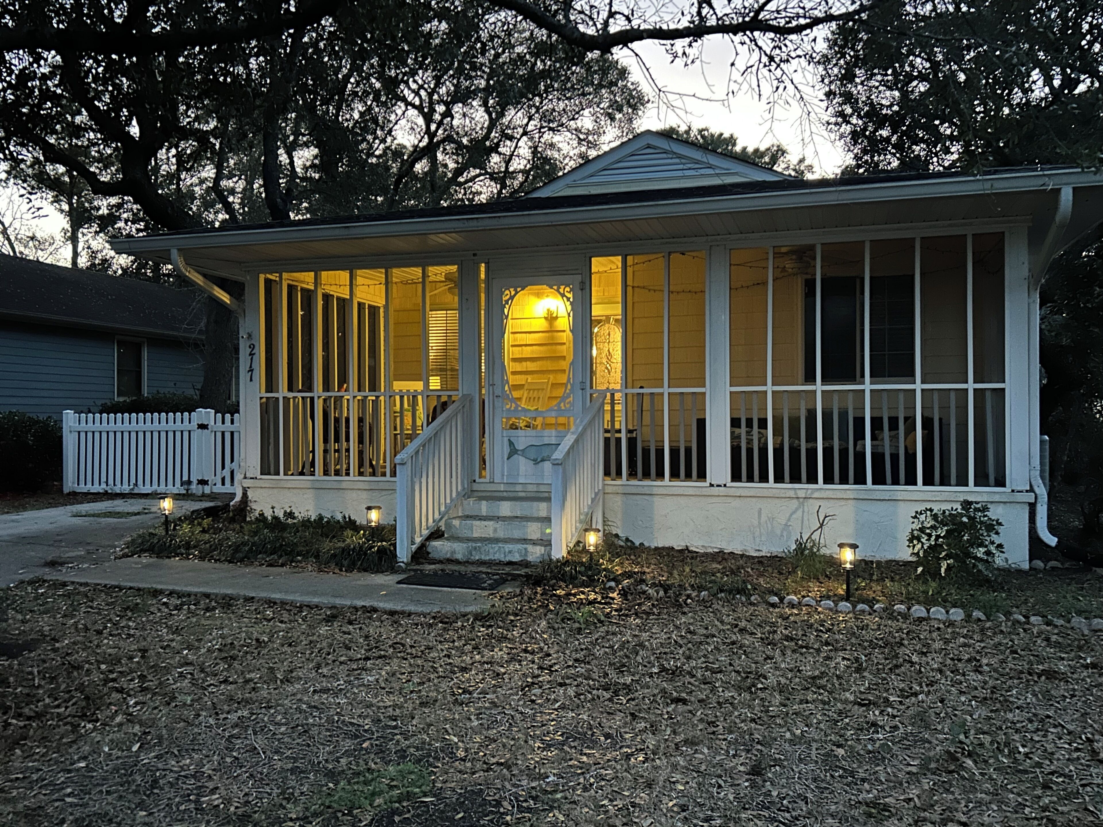 A single-story house with a porch, a front door, and a small staircase leading up to it.