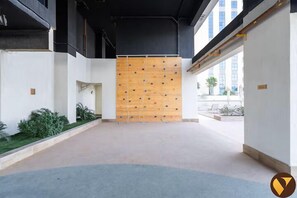 Un intérieur de bâtiment moderne avec un mur d’escalade, un couloir et une vue sur l’extérieur.