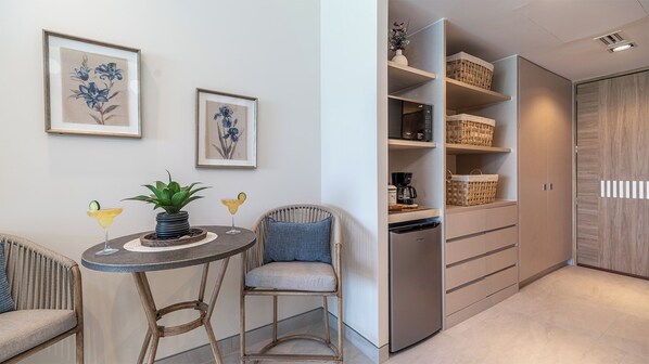 Een moderne keuken met een ingebouwde oven, een koffiezetapparaat en rieten manden op planken.