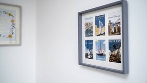 A framed collection of vintage maritime posters on a wall.