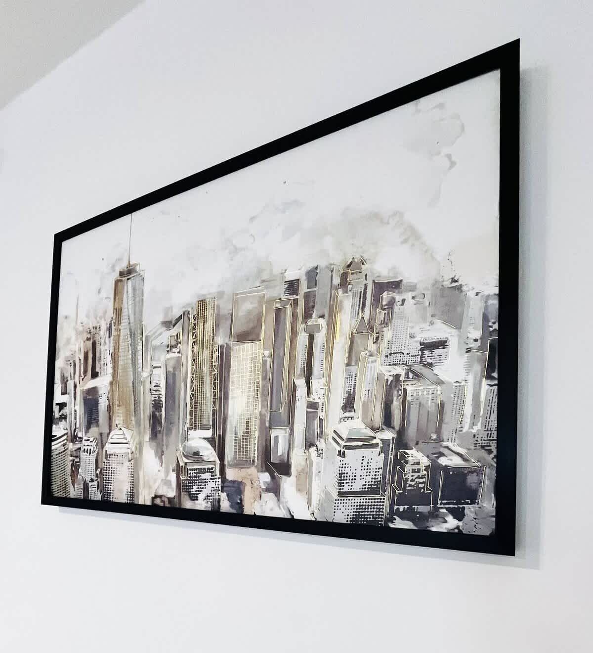 A framed cityscape artwork on a wall.