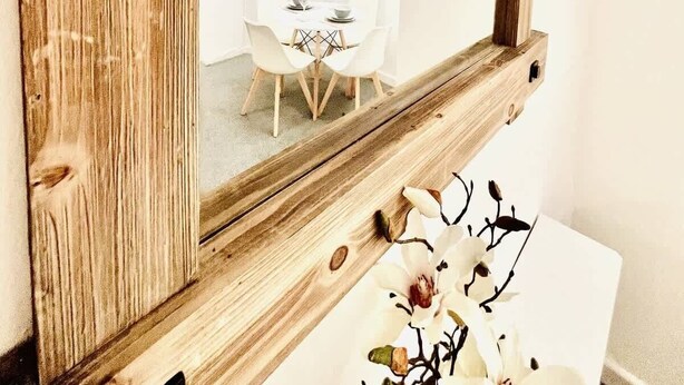 A wooden-framed mirror with a view of a dining area. - Portsmouth Apartment: Family friendly with Parking (Portsmouth)