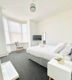 Tabla de planchar con plancha y ropa de cama