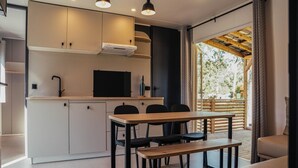 Una cocina moderna con comedor, horno empotrado y un amplio ventanal.