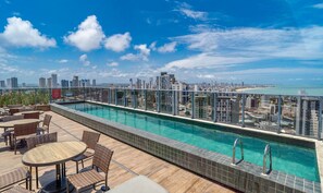 A rooftop pool with a city view, surrounded by wicker furniture and a tiled deck. - Comfort and Convenience Just 850m From Tambau Beach - Onws (João Pessoa)