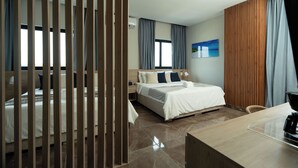 Quarto de hotel moderno com uma cama grande, uma escrivaninha e vista para a cidade.