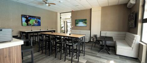 A conference room with a long table, multiple chairs, ceiling fans, and a large window.