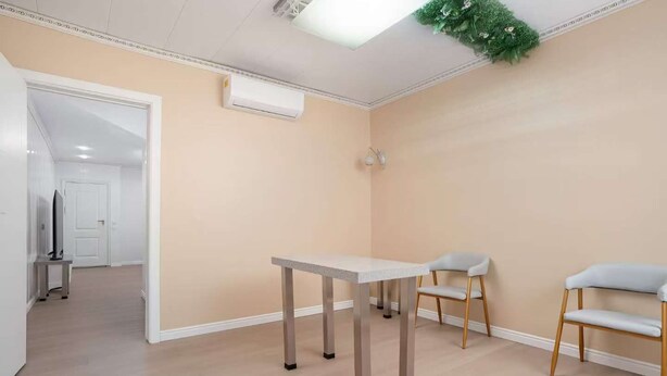 A room with a table and two chairs, a door, and an air conditioning unit. - air hotel aviacion  (Manises)