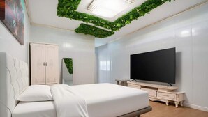 A bedroom with a bed, a TV, a wardrobe, and a mirror. - air hotel aviacion  (Manises)